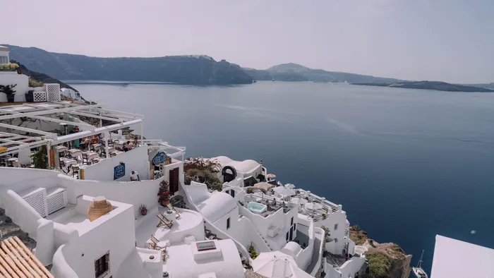 Whitewashed caldera-edge houses of Santorini looking out over the deep blue Aegean Sea